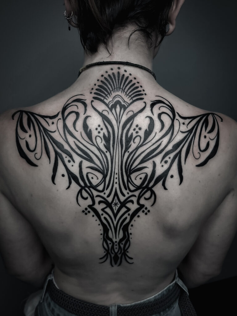 Tatouage symbolique sur un dos réalisé par Ely