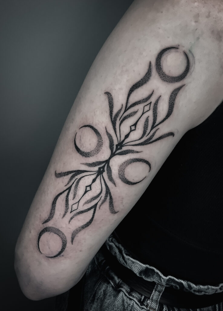 Tatouage symbolique sur un bras réalisé par Ely