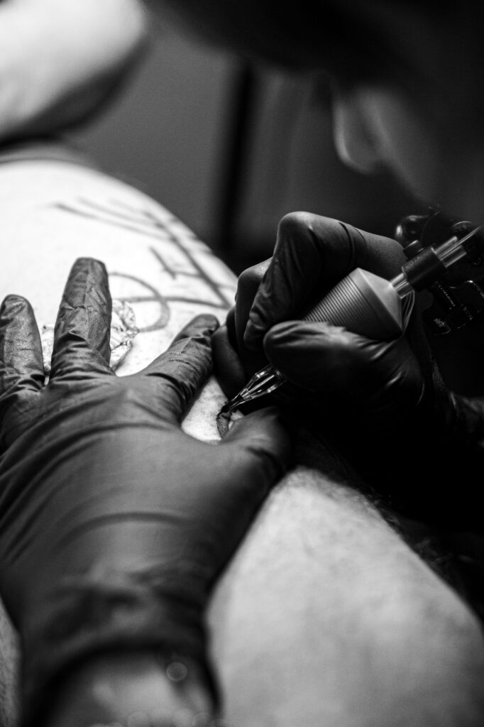 Portrait d'Ely Bournazel fondatrice de Balcksquad Tatooshop. Elle réalise un tatouage.